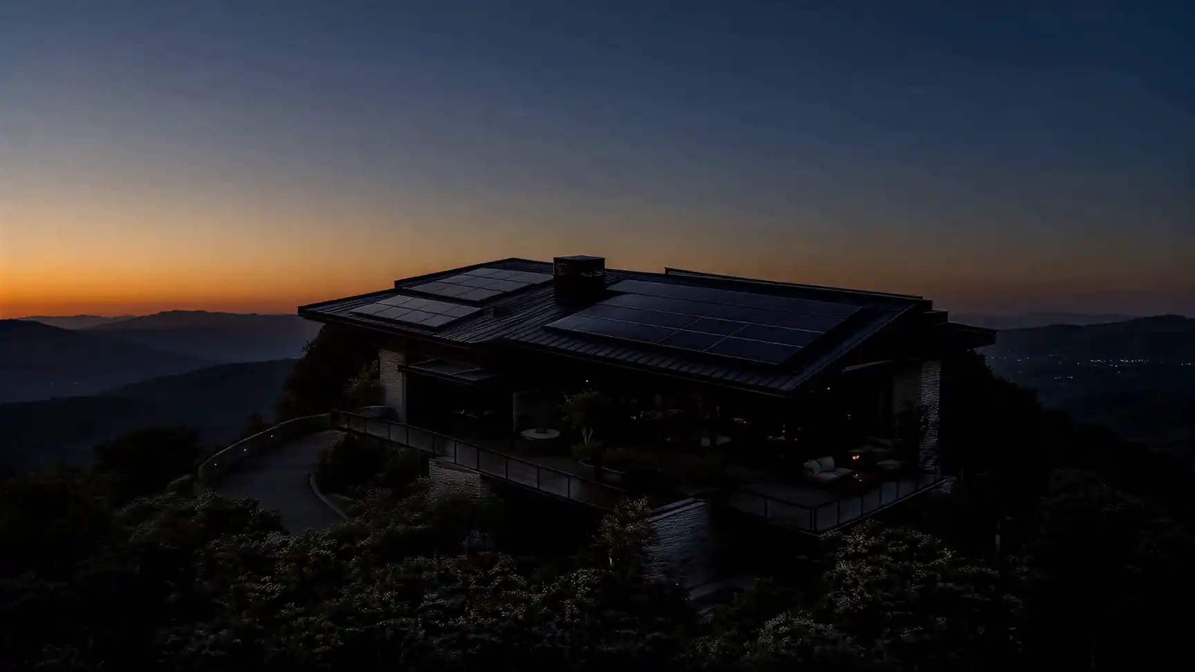 Modern hillside home with rooftop solar panels at first light